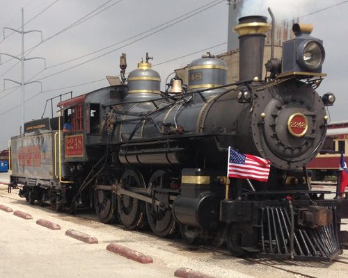 A train is parked on the tracks near power lines.