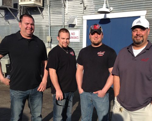 Four men standing in front of a building.